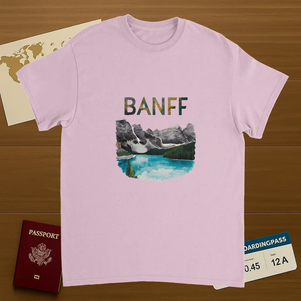 light pink Banff Canada Unisex Travel T-Shirt on wooden background with world map, passport, and boarding pass