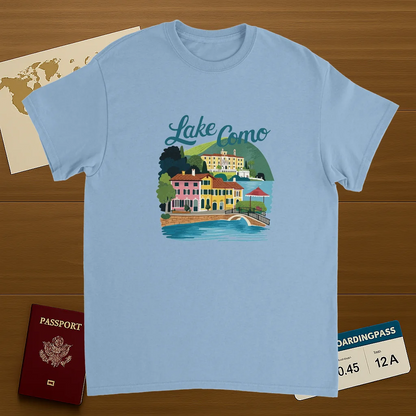 light blue Lake Como Italy Unisex Travel T-Shirt on wooden background with world map, passport, and boarding pass