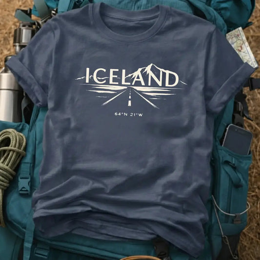 Navy blue t-shirt with 'ICELAND' design on a backpack with travel gear.