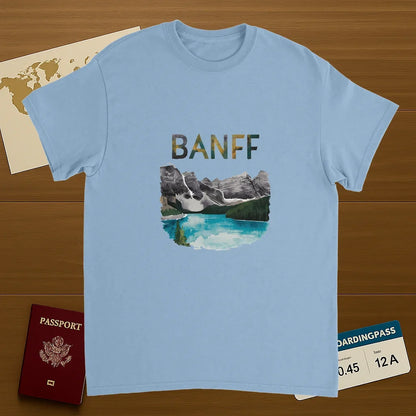 light blue Banff Canada Unisex Travel T-Shirt on wooden background with world map, passport, and boarding pass