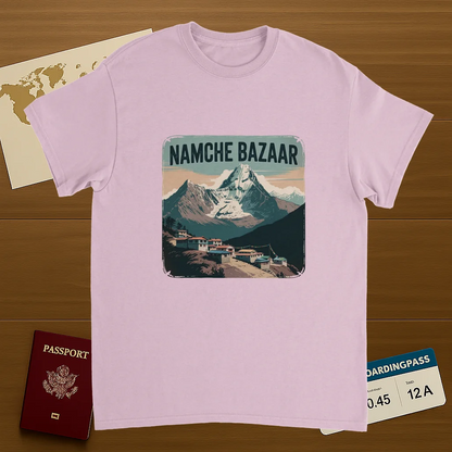 light pink Namche Bazaar Nepal Unisex Travel T-Shirt on wooden background with world map, passport, and boarding pass